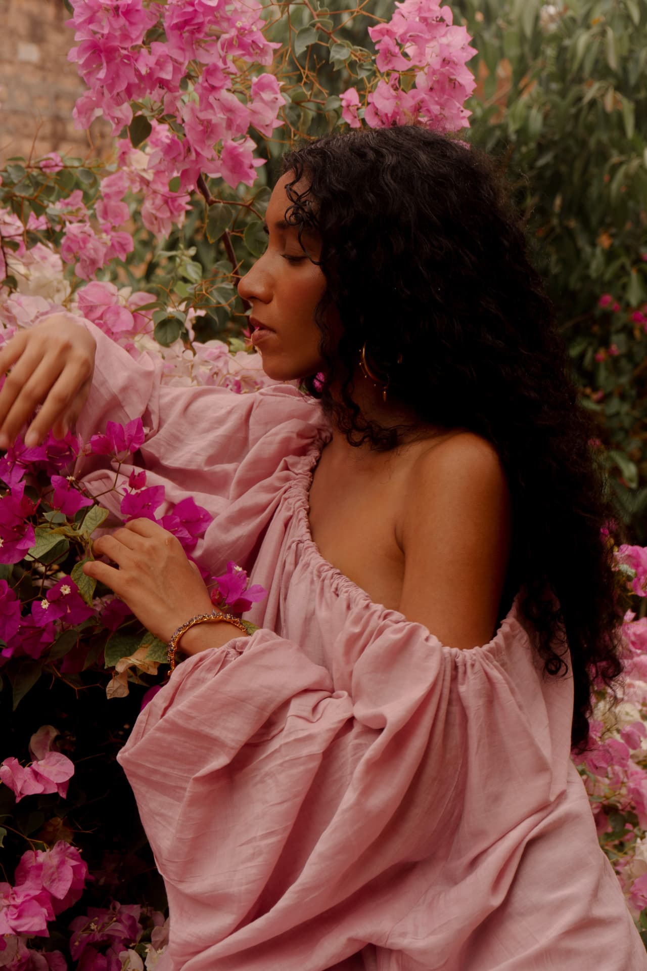 Detail of the Radha dress in soft pink silk amid pink blossoms
